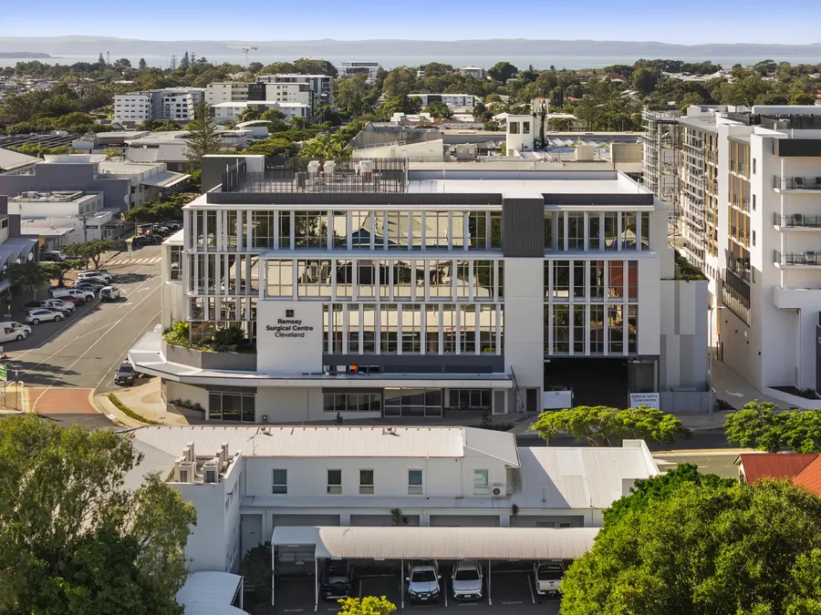 Aerial photo over Cleveland Health and the surrounding town centre, with Moreton Bay on the horizon